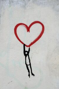 graffiti person being lifted by a red heart self care self love